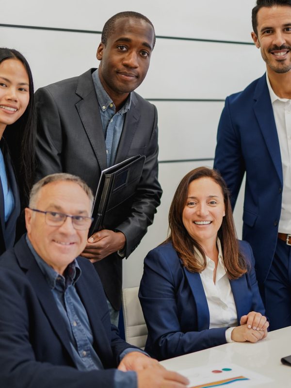 Multiracial business people smiling on camera inside modern office